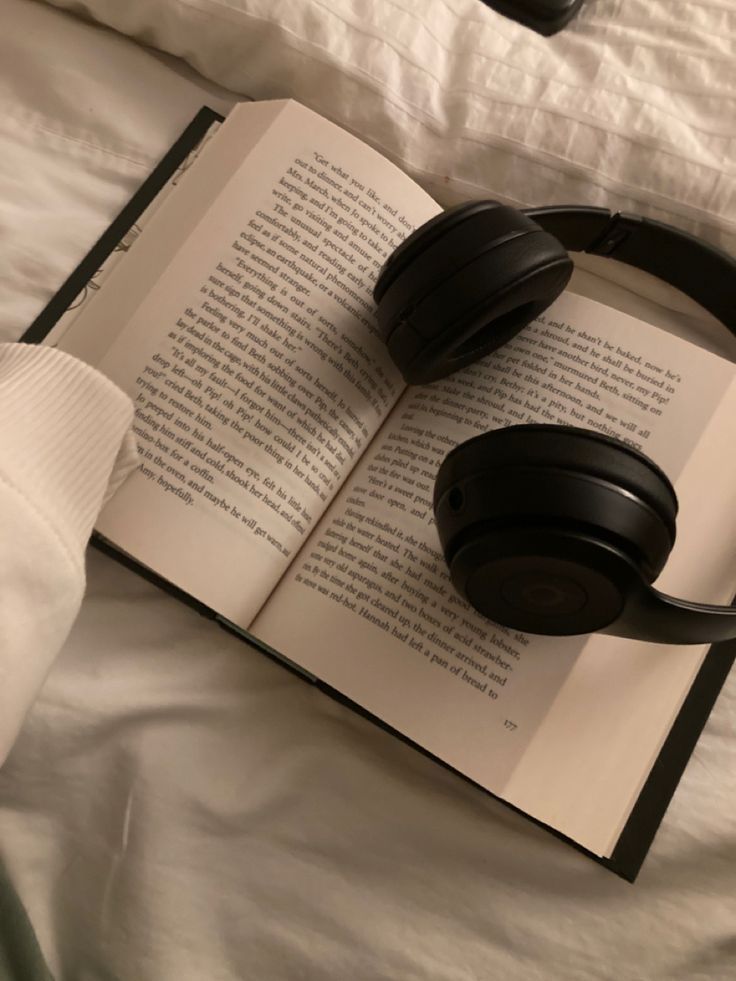 open book with headphones upon it 